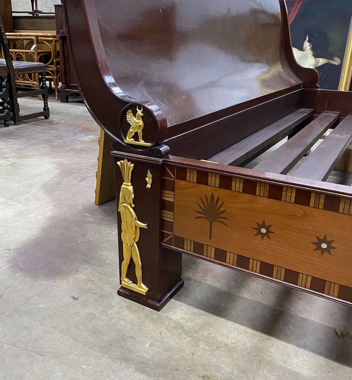 A reproduction Egyptian style inlaid gilt metal mounted mahogany sleigh bedframe, width 193cm, length 261cm, height 110cm